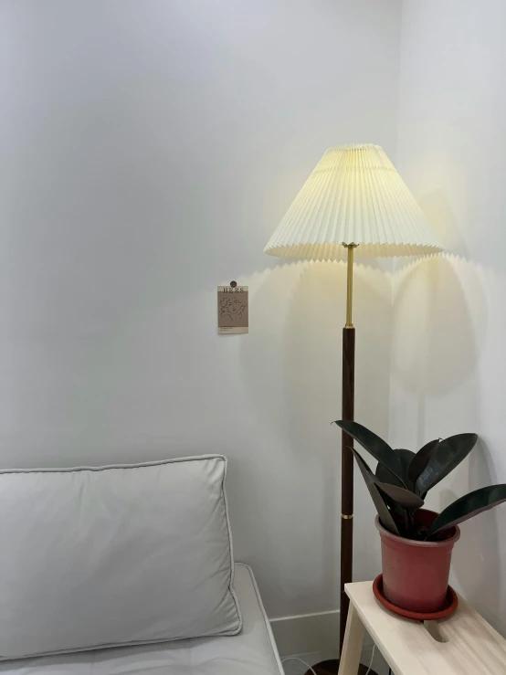 the floor lamp is on beside a white couch