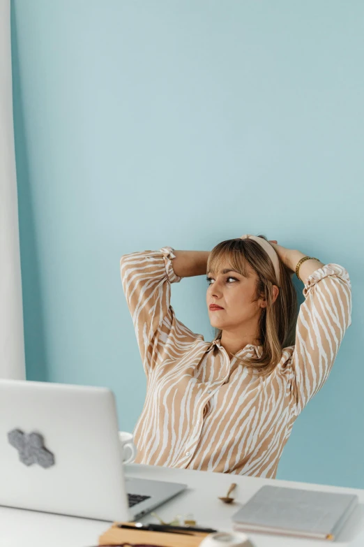 a woman is sitting at a table with her laptop