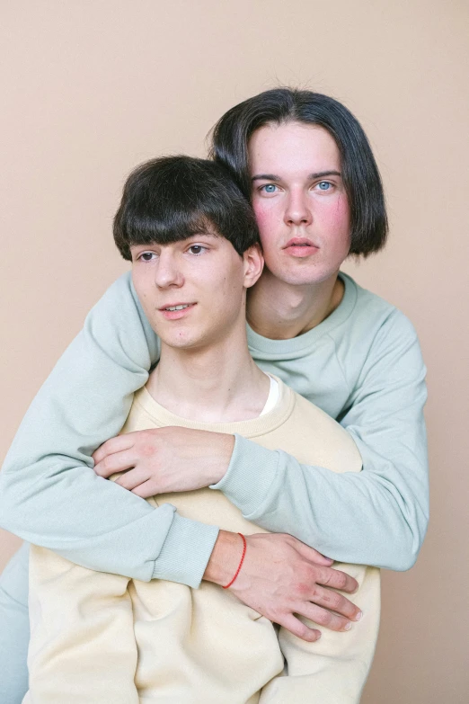 two people sitting in front of a tan wall