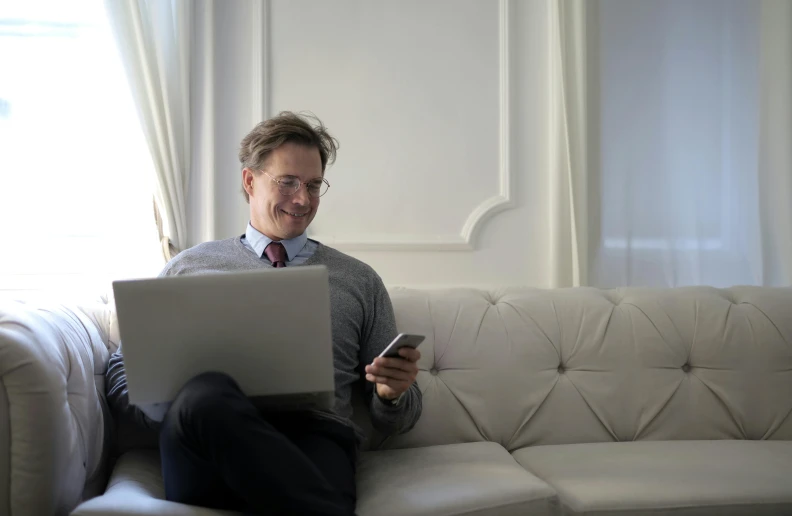 a man on his cell phone and laptop