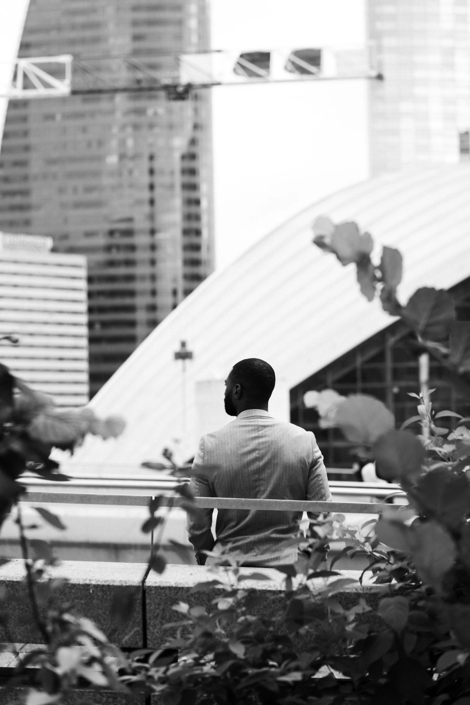 a black and white image of a person sitting on a bench