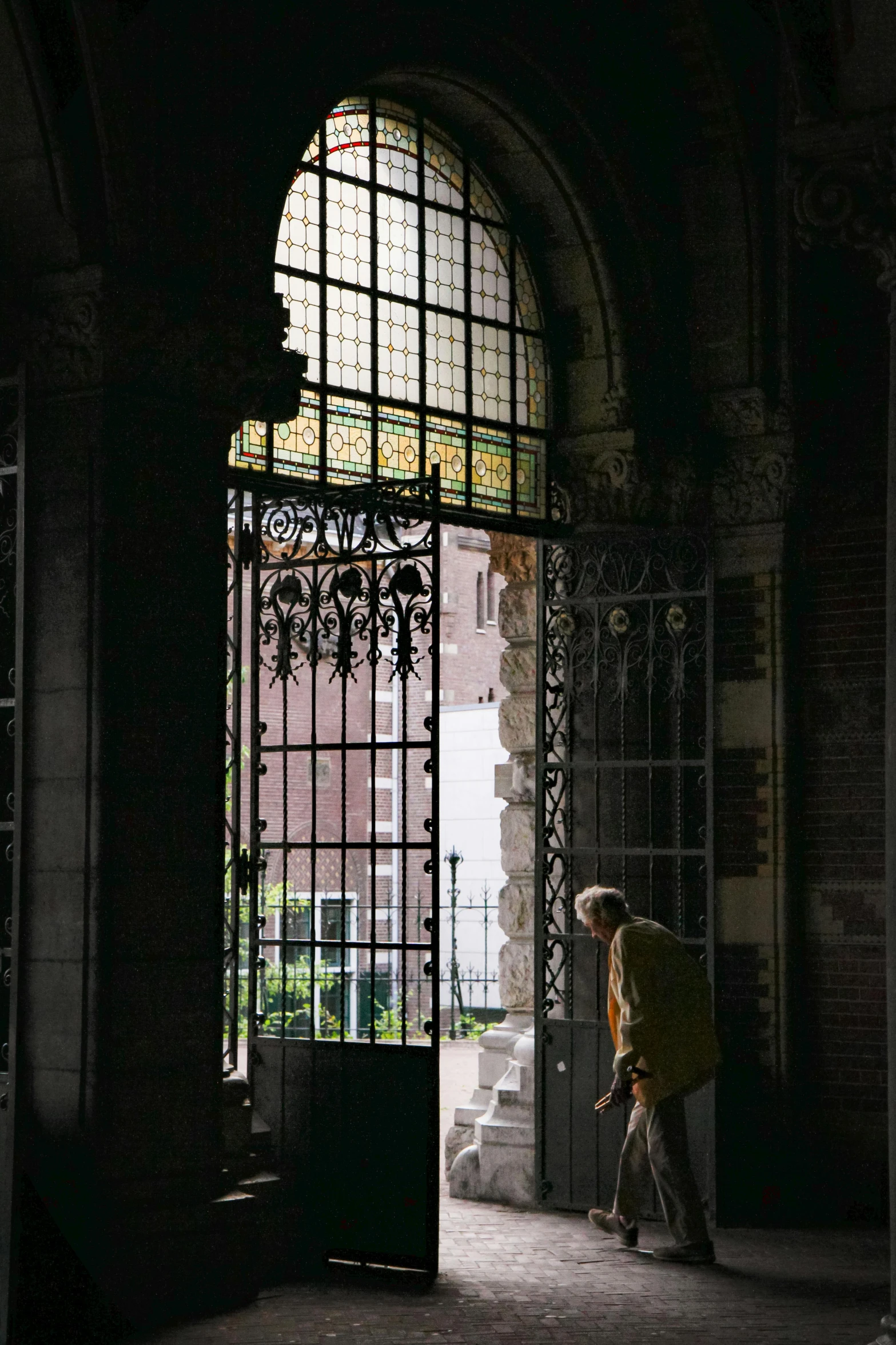 person with yellow umbrella near entrance to building