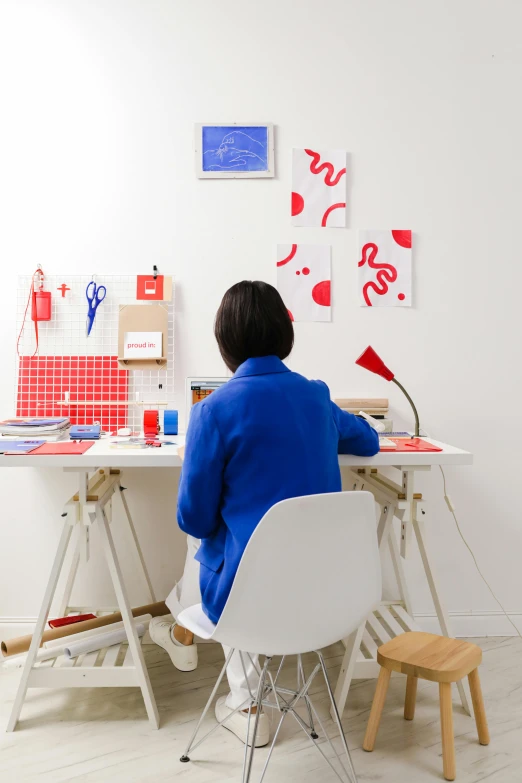 a woman sitting at a table working on paper