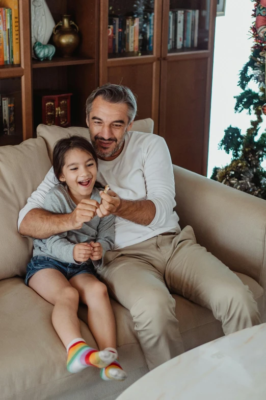 man and young child posing on the sofa