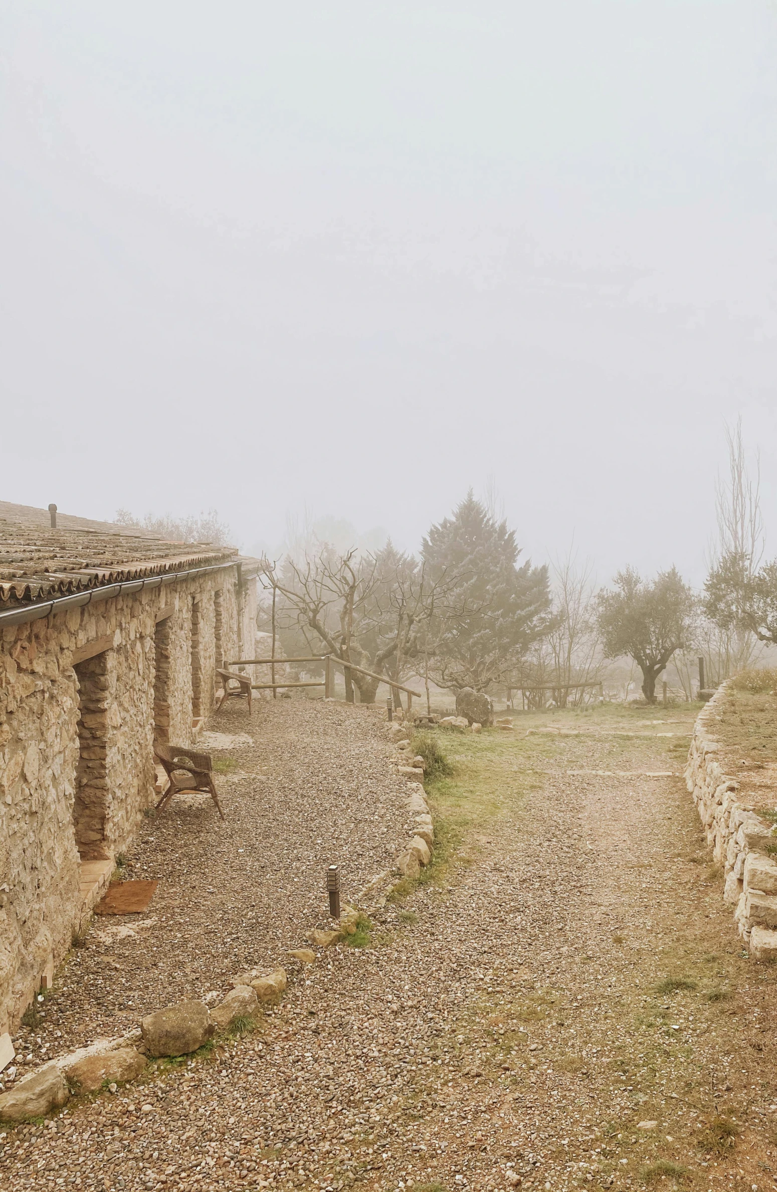 an empty road lined with stones under some cloudy skies