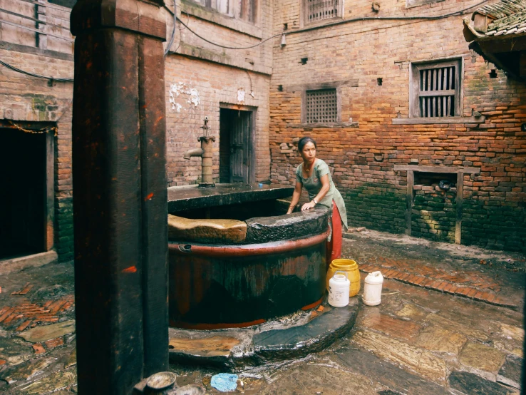 a woman stands beside a large pot in an old - world city