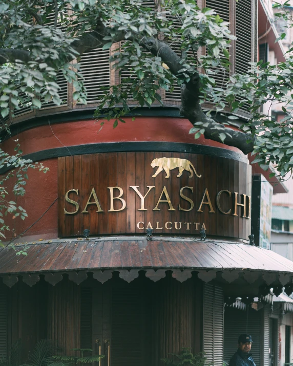 a restaurant in the middle of a city with a large sign above the door