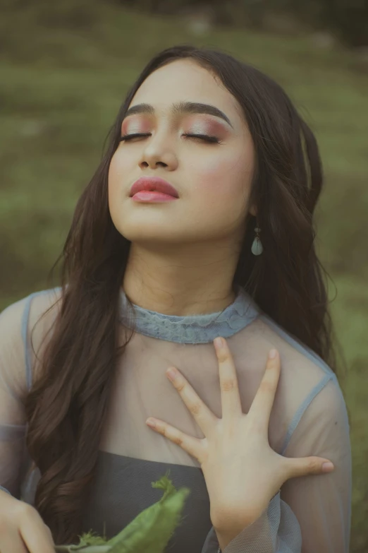 a girl with a pink lip holding a green leafy plant