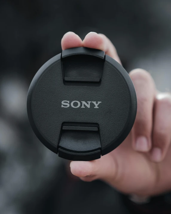 a person holding a remote control with the word sony engraved on it