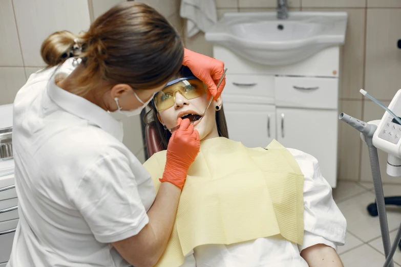 a girl wearing an eye patch sits in a chair and is having her teeth cleaned