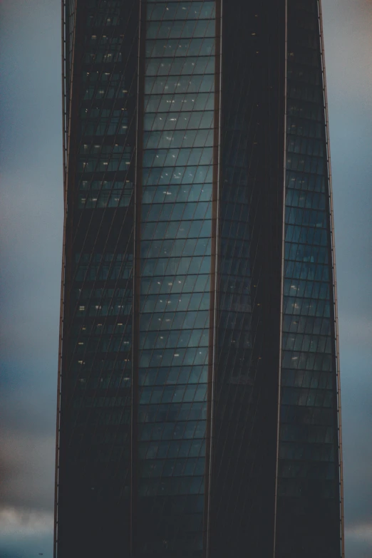 a tall building has dark glass covering it