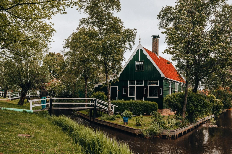 a house along the water with a small bridge next to it