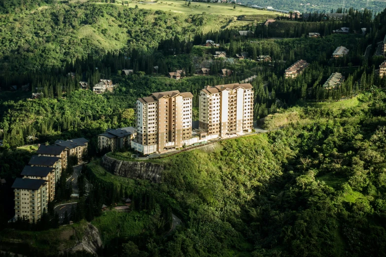 a long, three story building is standing in the middle of green trees