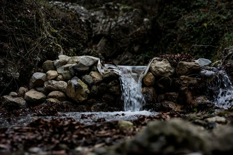 a waterfall surrounded by rocks and some trees