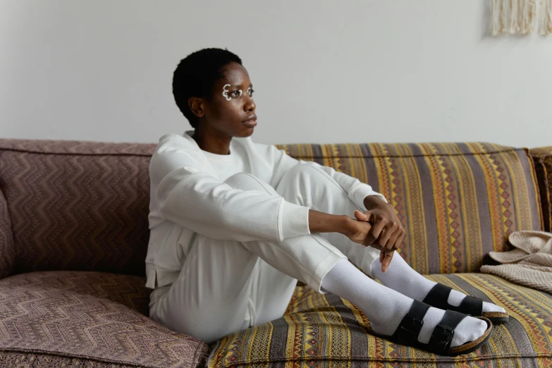 a woman sitting on the couch with her foot up