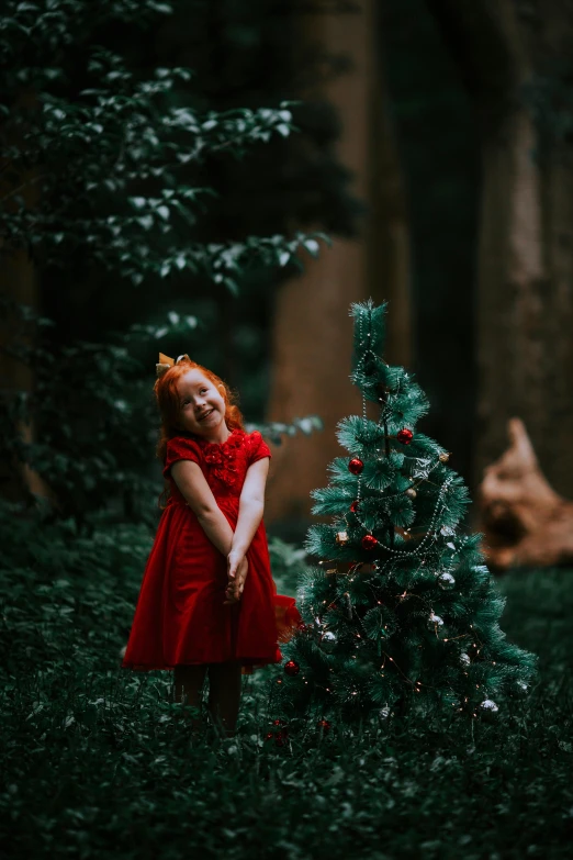 an image of a little girl by a christmas tree