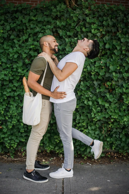 two men hugging each other while walking down the street