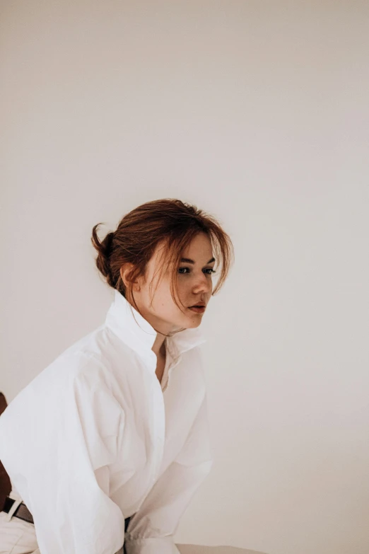 a woman with red hair in a white shirt