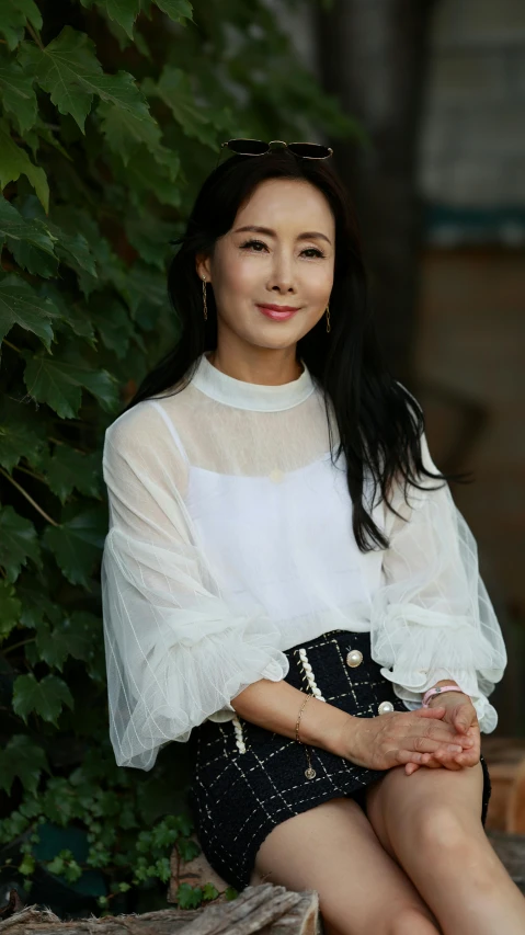 a woman sitting with her hands crossed smiling