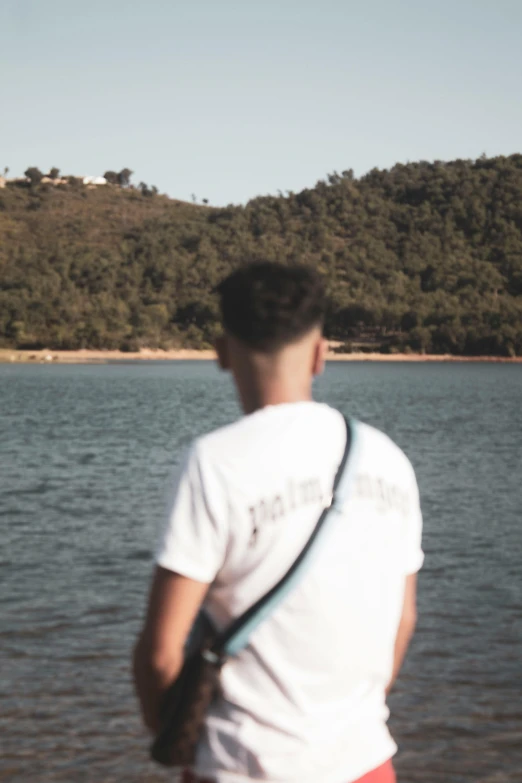 a man is holding an object near the water