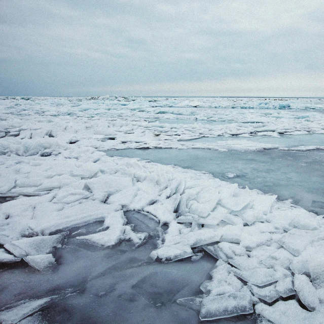 an icy ocean with waves breaking on rocks and ice