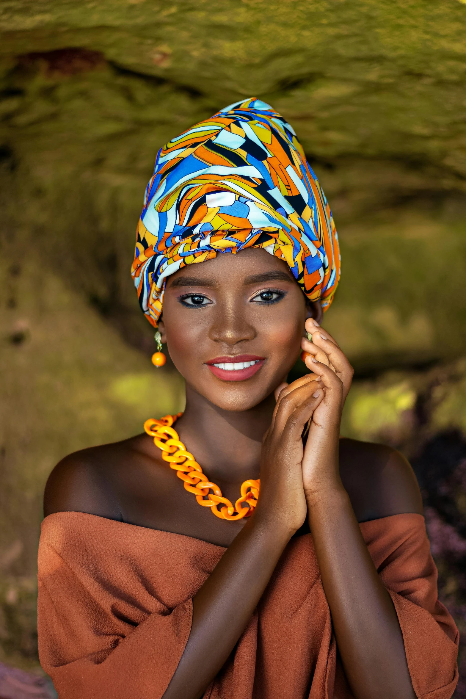 an african woman wearing an orange top and a yellow necklace