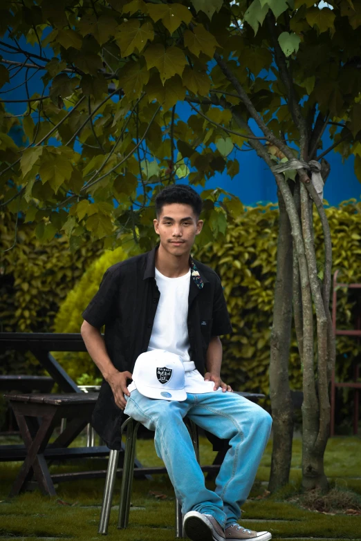 a young man sitting on top of a chair