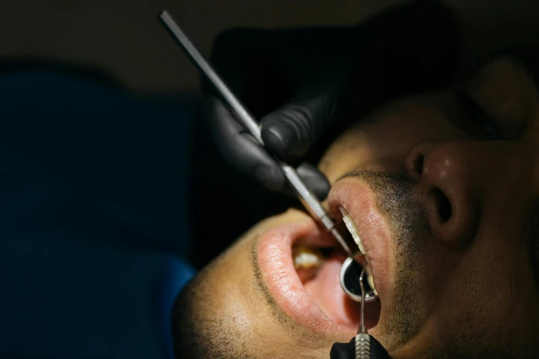 a young man with contactless eyeliners getting an ear tattoo