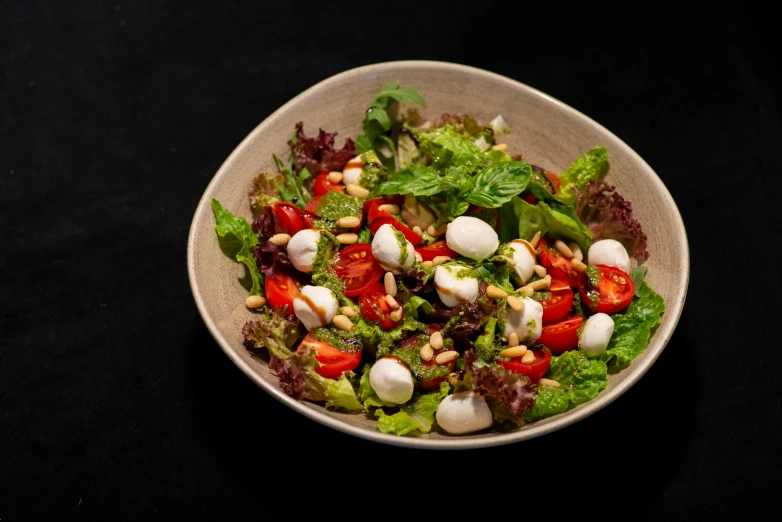 a plate of salad is shown on a black surface