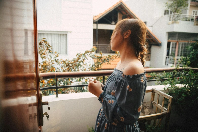 a woman is standing on a balcony staring into the distance