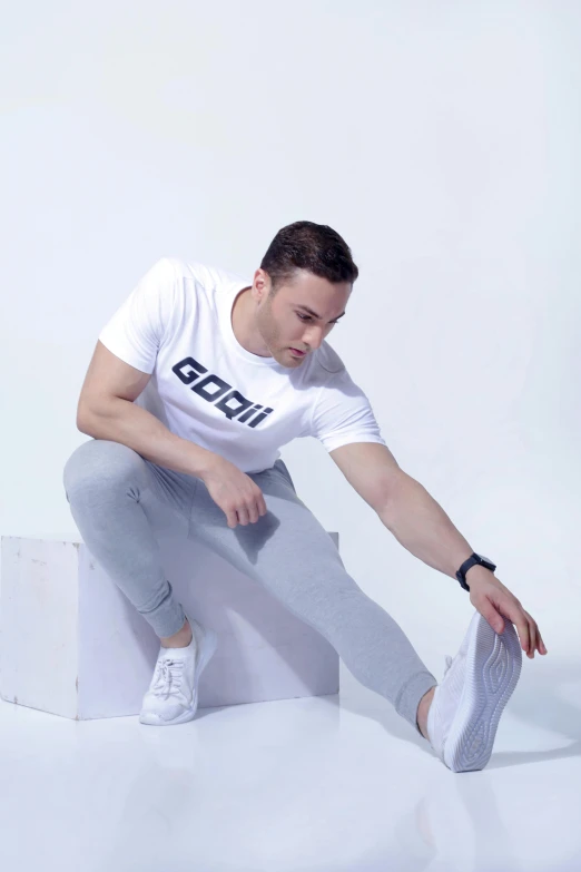 a man squatting on the ground with his sneakers on