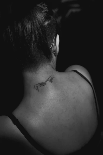 the back of a womans neck and behind of her head is a bird on a nch tattoo