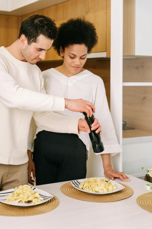 a young couple is preparing dinner in the kitchen