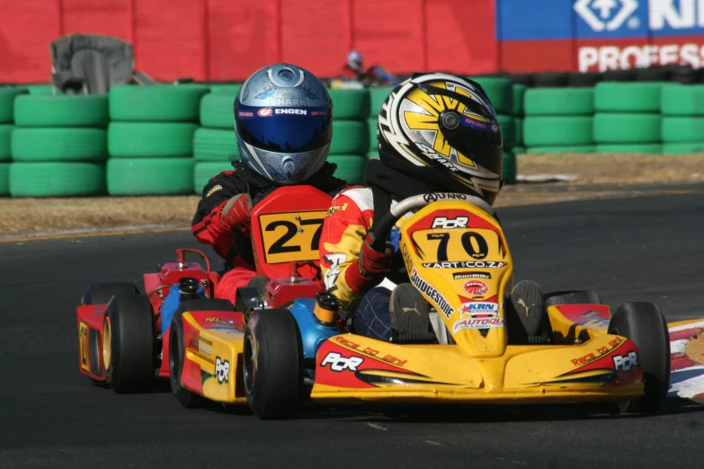 a couple of s riding down a track in kart