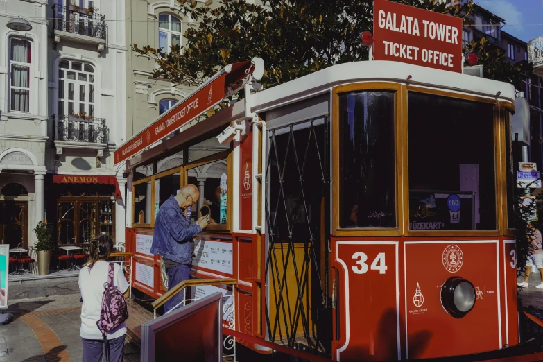 two people near an old fashioned trolley car