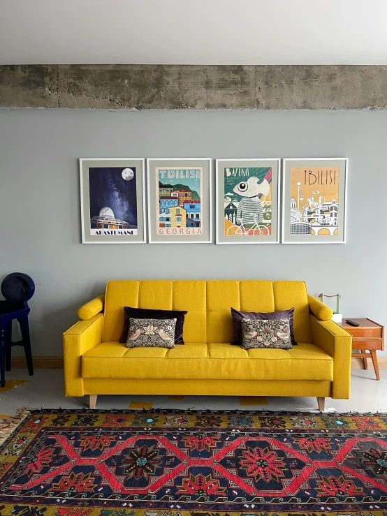 a living room with yellow couches, and posters on the wall