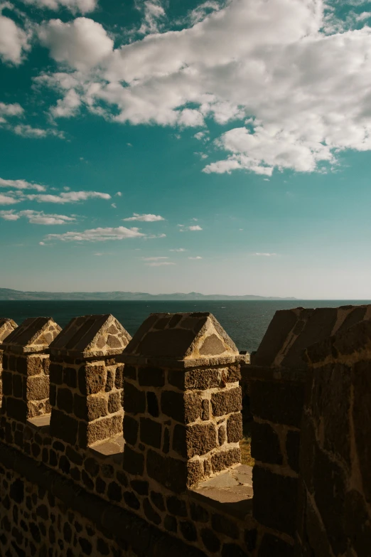 a person flying a kite on a stone wall