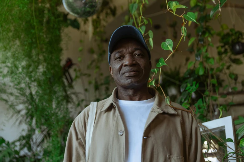 an older man is standing in front of a plant