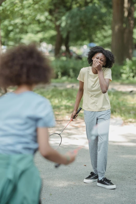 a woman talking on the phone while holding a tennis racket