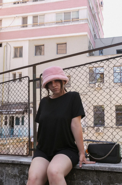 a woman in a pink hat poses for the camera