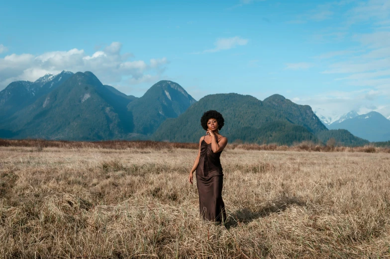 a woman is posing in a field for a po