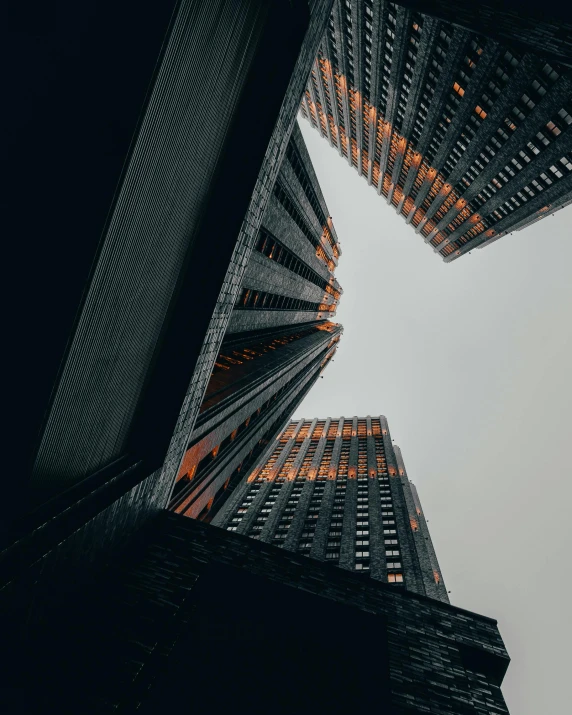 an upward view of two skyscrs taken from below in the evening