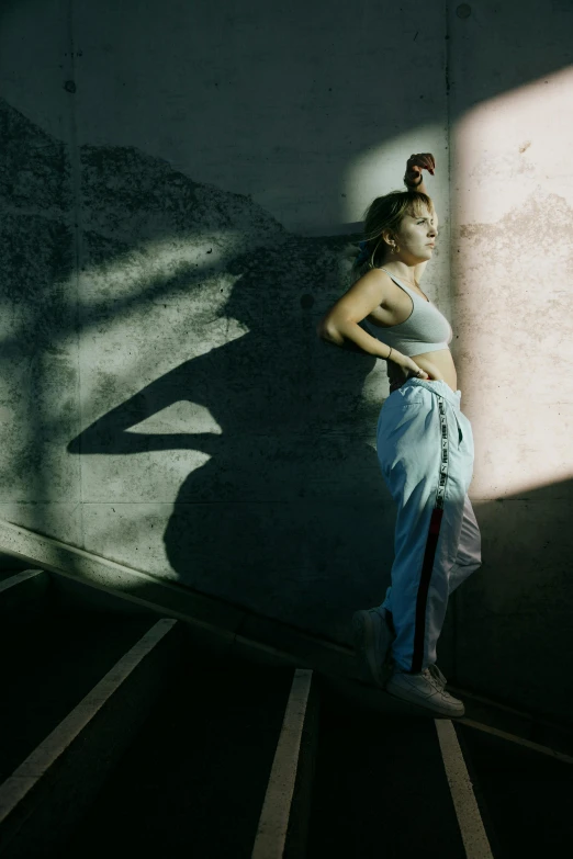 a woman leaning against a wall on a stairwell