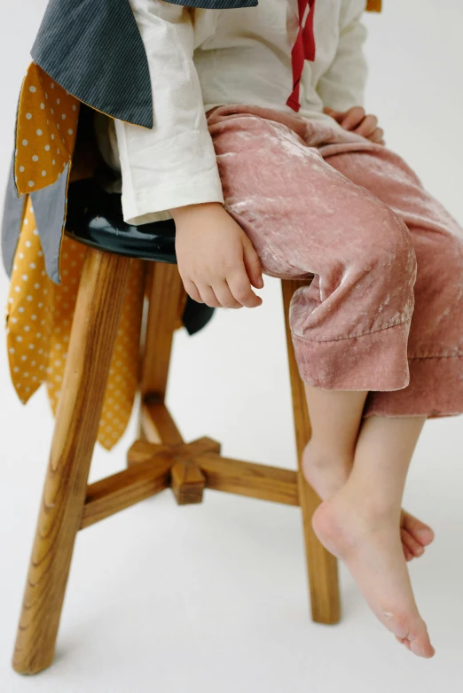 a small child is sitting on top of a stool