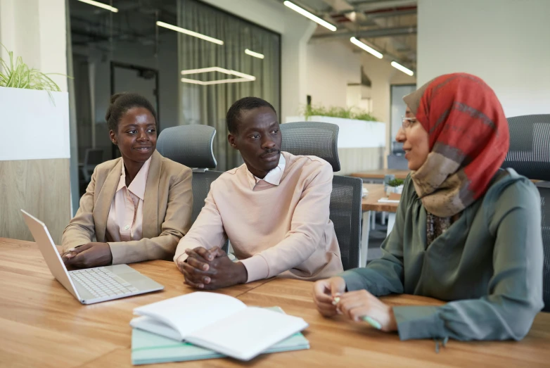 three business people sitting around a wooden table