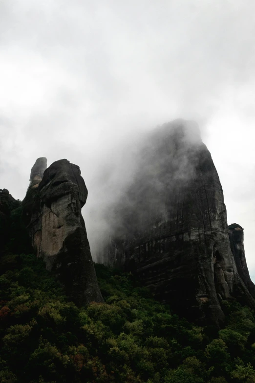 a large rock in the distance surrounded by trees