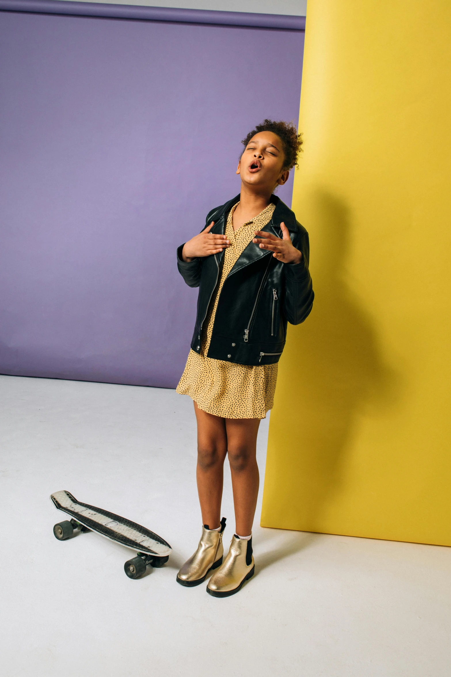 a person leaning against a large wall near a skate board