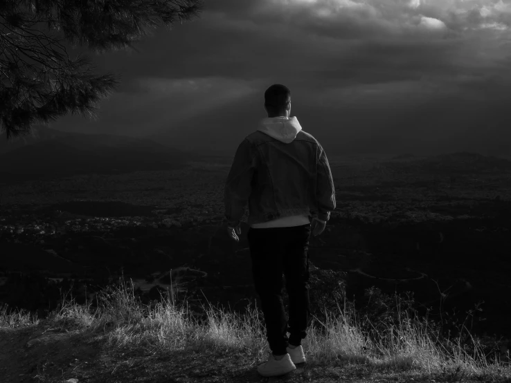 black and white pograph of man looking out over the valley