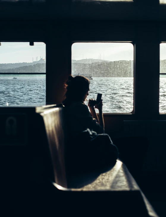 a girl on the bus with a cellphone near a window