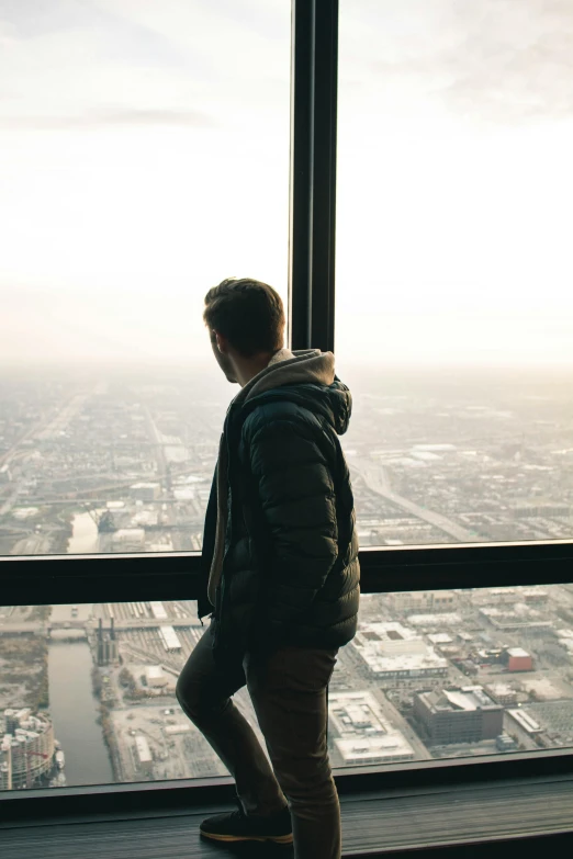 a young man standing on the edge of a tall tower